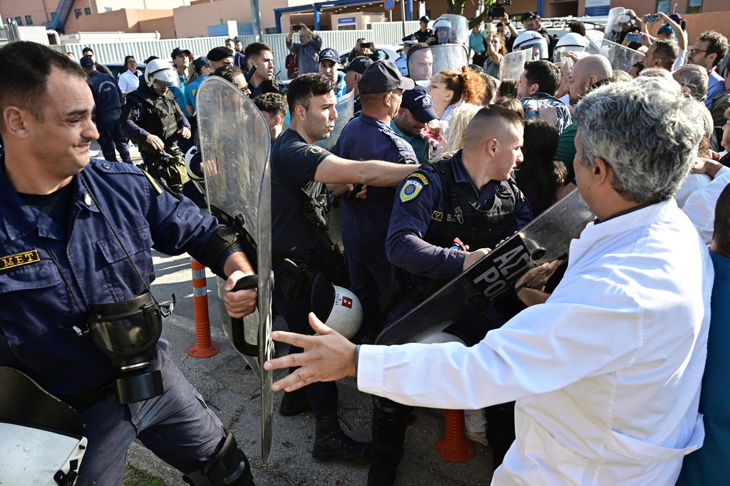Riot police scuffle with medical workers after the staff gathered to protest the state of public health services during a visit to the hospital by the country's prime minister in Athens, Greece, Wednesday, Oct. 15, 2025. (Michalis Karayiannis/Eurokinissi via AP)