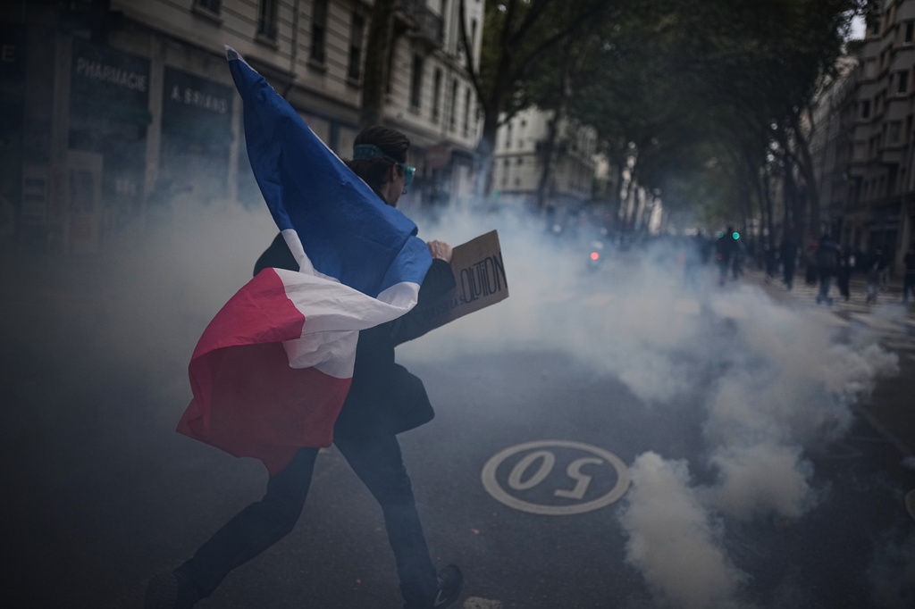 A protester holds a French flag during a demonstration against rising living costs in Lyon, France, Saturday, Oct. 24, 2026. (AP Photo/Laurent Cipriani)