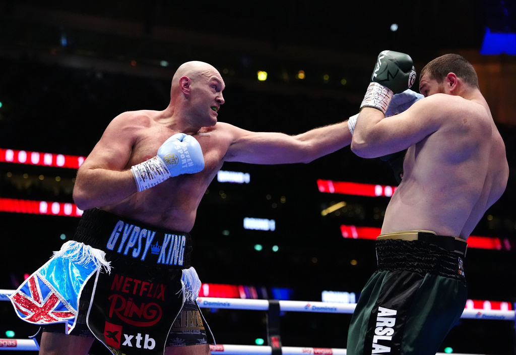 Boxer Tyson Fury, left, punches Arslanbek Makhmudov during a heavyweight bout at Tottenham Hotspur Stadium in London, Saturday, April 11, 2026. (Bradley Collyer/PA via AP)