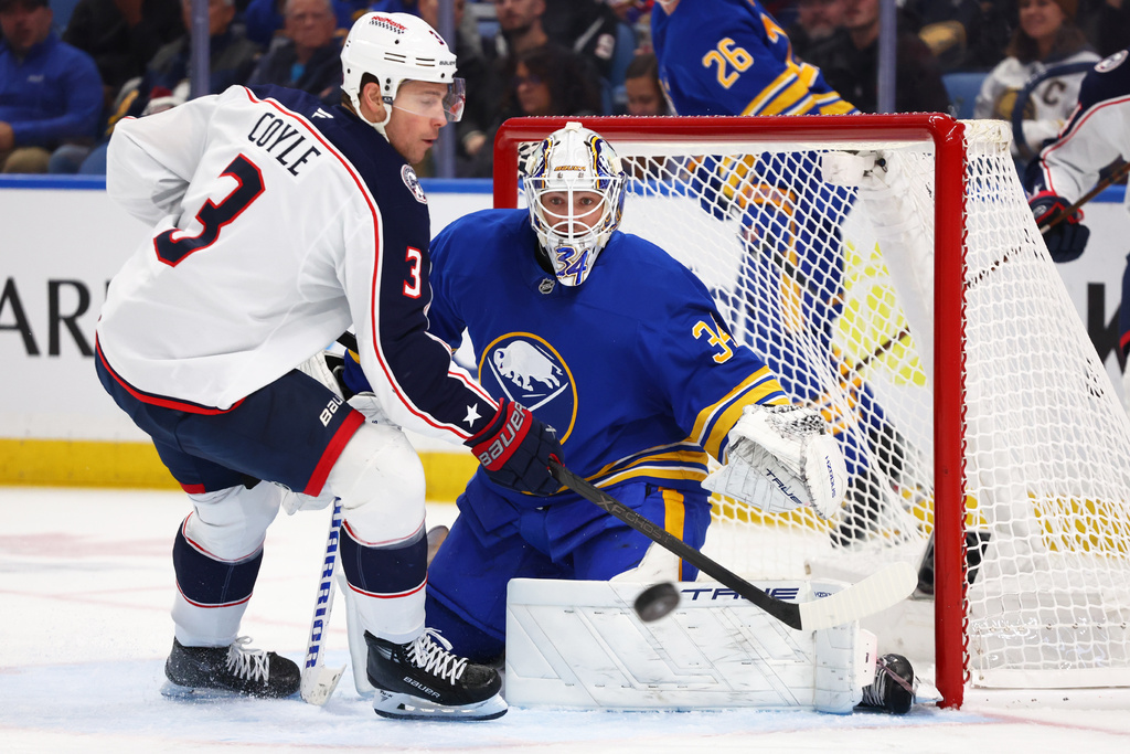 Columbus Blue Jackets center Charlie Coyle (3) is stopped by Buffalo Sabres goaltender Alex Lyon (34) during the second period of an NHL hockey game Tuesday, Oct. 28, 2025, in Buffalo, N.Y. (AP Photo/Jeffrey T. Barnes)