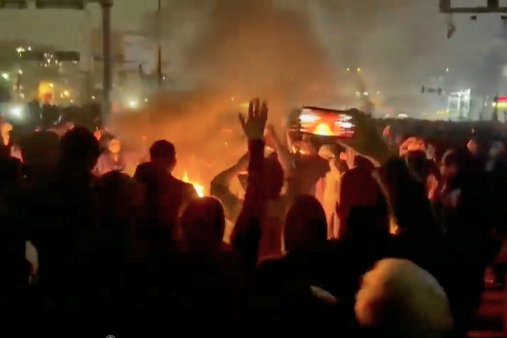 FILE - In this image from video circulating on social media, protesters dance and cheer around a bonfire as they take to the streets of Tehran, Iran, on Jan. 9, 2026. (UGC via AP, File)