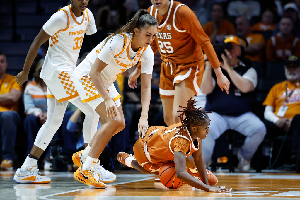 Texas guard Bryanna Preston (1) falls to the floor as she battles for the ball with Tennessee forward Lauren Hurst (7) during the first half of an NCAA college basketball game in Knoxville, Tenn., Sunday, Feb. 15, 2026. (AP Photo/Wade Payne)