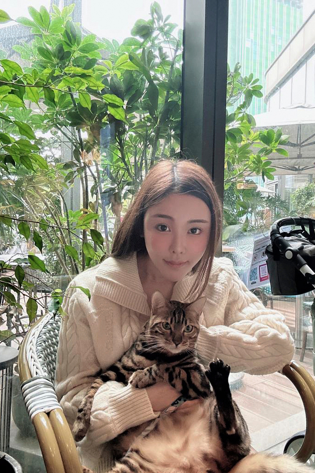 Abby Choi holds a cat and poses, Feb. 11, 2023, in Hong Kong. (AP Photo)