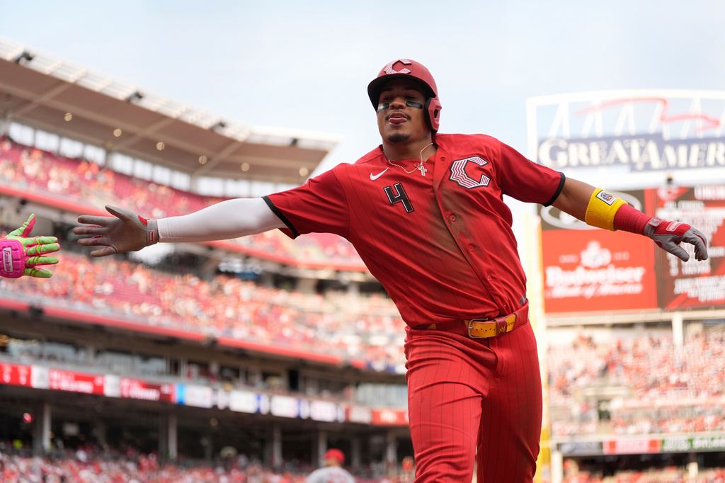 Cincinnati Reds' Noelvi Marte reaches for Elly de la Cruz's hand to celebrate after scoring on a wild pitch by Los Angeles Angels pitcher Chase Silseth during the eighth inning of a baseball in Cincinnati, Saturday, April 11, 2026. (AP Photo/Carolyn Kaster)
