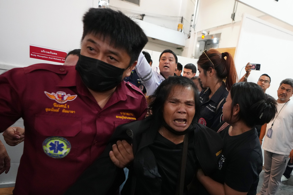 A relative of a victim in a music bar fire cries while receiving the victim's body at a police hospital in Bangkok, Thailand, Tuesday, July 14, 2026. (AP Photo/Sakchai Lalit)