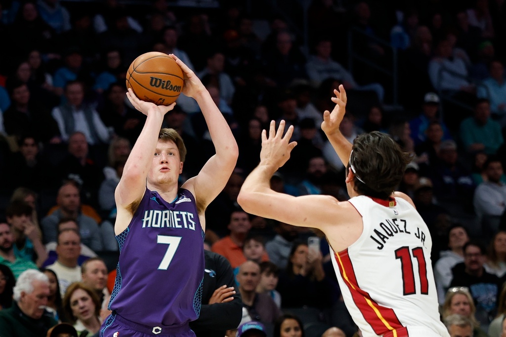 Charlotte Hornets guard Kon Knueppel (7) shoots against Miami Heat forward Jaime Jaquez Jr. during the first half of an NBA basketball game, Tuesday, March 17, 2026, in Charlotte, N.C. (AP Photo/Nell Redmond)