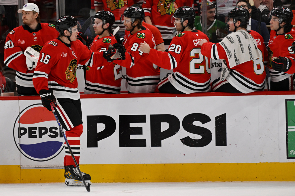 Chicago Blackhawks' Anton Frondell (16) celebrates with teammates at the bench after scoring a goal during the first period of an NHL hockey game against the Carolina Hurricanes in Chicago, Thursday, April 9, 2026. (AP Photo/Paul Beaty)