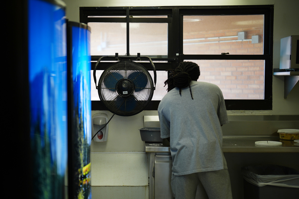 A fan blows air inside while a person who is incarcerated washes dishes in a housing unit at the Minnesota Correctional Facility in Lino Lakes, Minn., Tuesday, Sept. 15, 2026. (AP Photo/Ellen Schmidt)