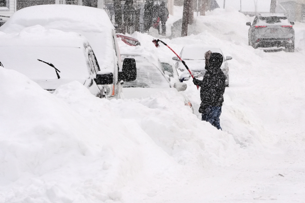 Rafael Tavares digs his car, which was encased about 20 inches of snow, during a winter storm, Monday, Jan. 26, 2026, in Lawrence, Mass. (AP Photo/Charles Krupa)