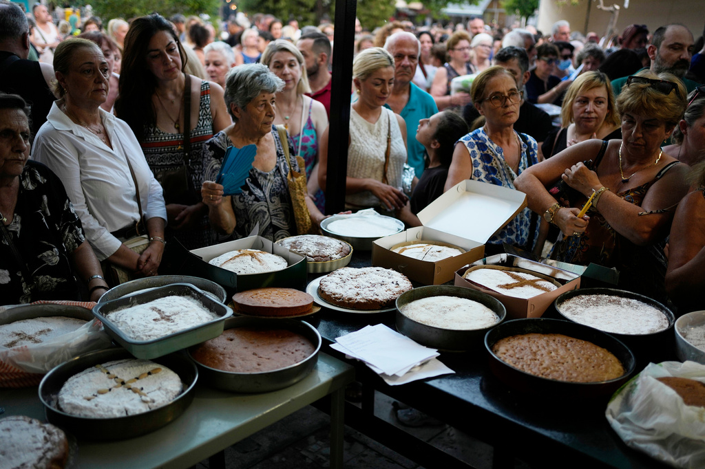 Pilgrims wait in line to have their Fanouropites, orange-flavored cakes, blessed at the Church of St. Fanourios in Athens, Wednesday, Aug. 26, 2026. (AP Photo/Thanassis Stavrakis)