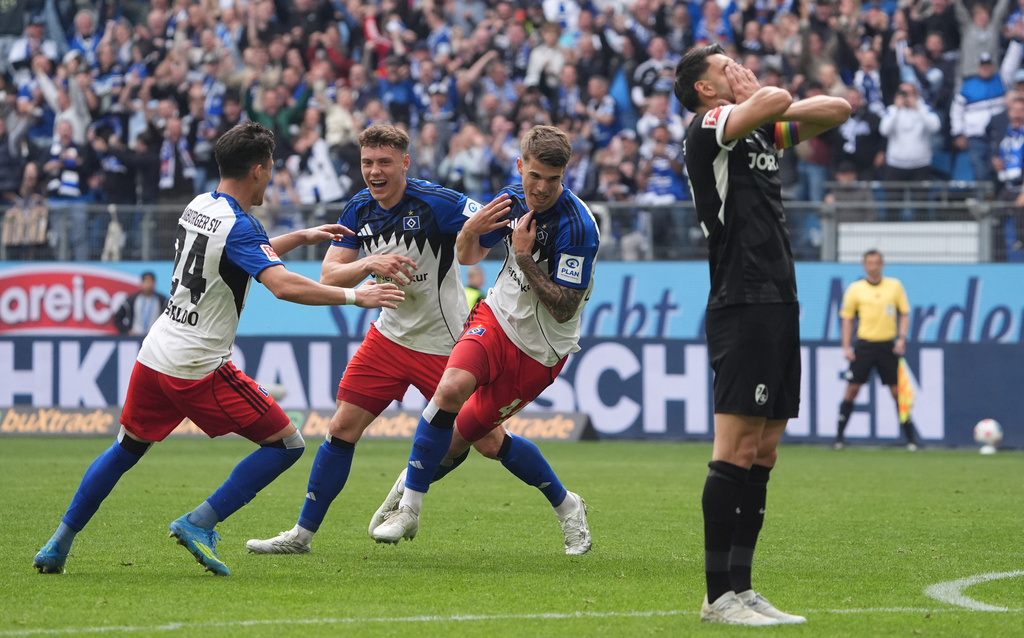 Hamburger's Luka Vuskovic, centre, celebrates with Nicolai Remberg, second from left, and Nicolas Capaldo after scoring his side's second goal during the German Bundesliga soccer match between Hamburger SV and Sport-Club Freiburg in Hamburg, Germany, Sunday, May 10, 2026. (Marcus Brandt/dpa via AP)