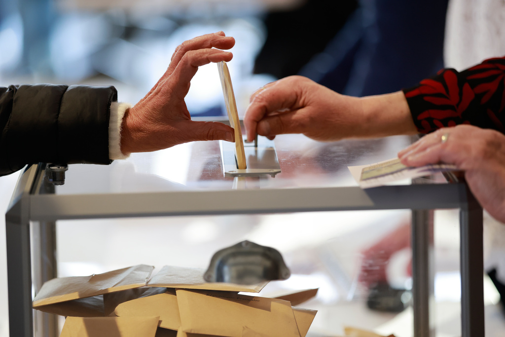 A woman castes her ballot during the first round of France's municipal elections in Henin-Beaumont, northern France, Sunday, March 15, 2026. (AP Photo/Jean-Francois Badias)