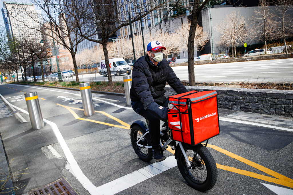 FILE - A delivery worker rides his bicycle along a path on the West Side Highway in New York on March 16, 2020. (AP Photo/John Minchillo, File)