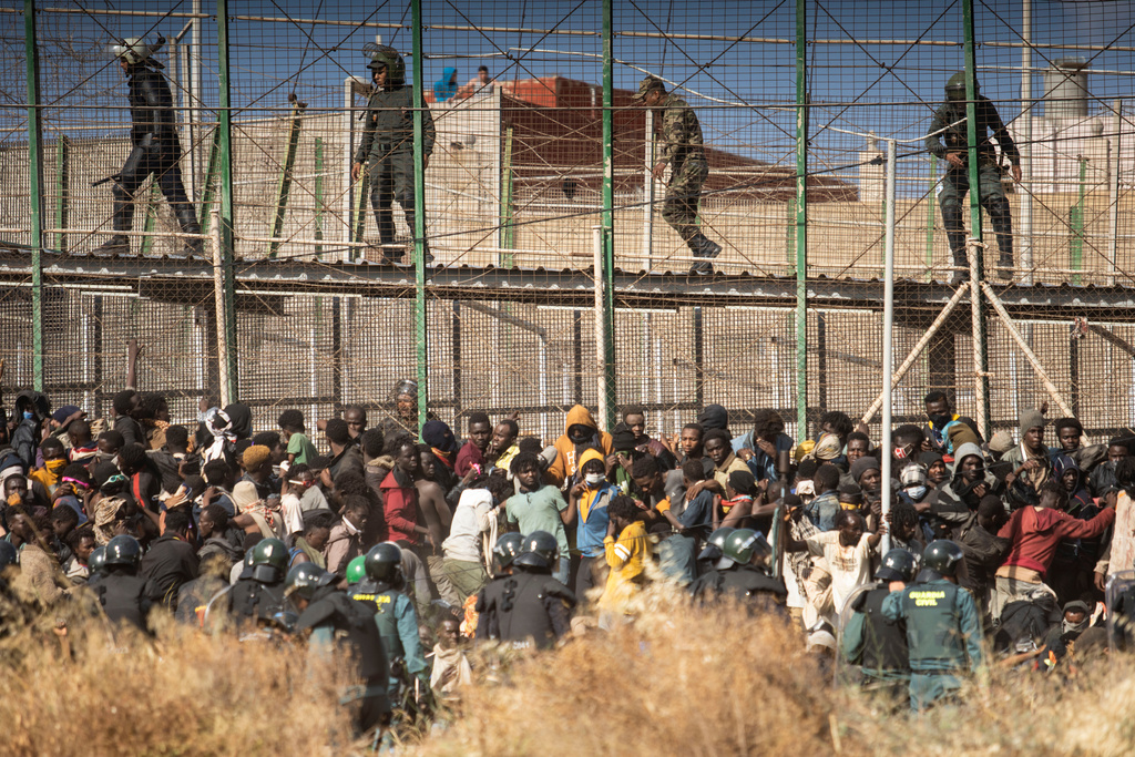 FILE - Riot police officers cordon off the area after migrants arrive on Spanish soil and crossing the fences separating the Spanish enclave of Melilla from Morocco in Melilla, Spain, on June 24, 2022. (AP Photo/Javier Bernardo, File)