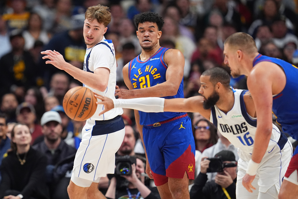 From left to right, Dallas Mavericks forward Cooper Flagg, Denver Nuggets forward Spencer Jones, Mavericks forward Caleb Martin and Nuggets center Nikola Jokić pursue the ball in the first half of an NBA basketball game Monday, Dec. 1, 2025, in Denver. (AP Photo/David Zalubowski)