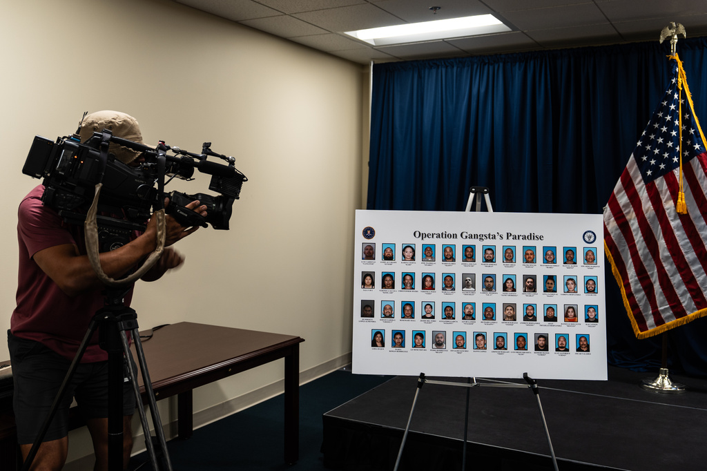 A cameraman records a board displaying individuals identified by law enforcement as members and associates of the Mexican Mafia at a news conference in Santa Ana, Calif., Thursday, April 23, 2026. (AP Photo/Jae C. Hong)