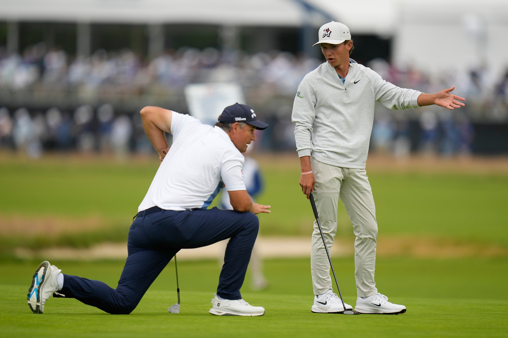 Miles Russell and Padraig Harrington, of Ireland, talk on the fourth hole during the first round of the U.S. Open golf tournament at Shinnecock Hills Golf Club in Southampton, N.Y., Thursday, June 18, 2026.(AP Photo/Seth Wenig)
