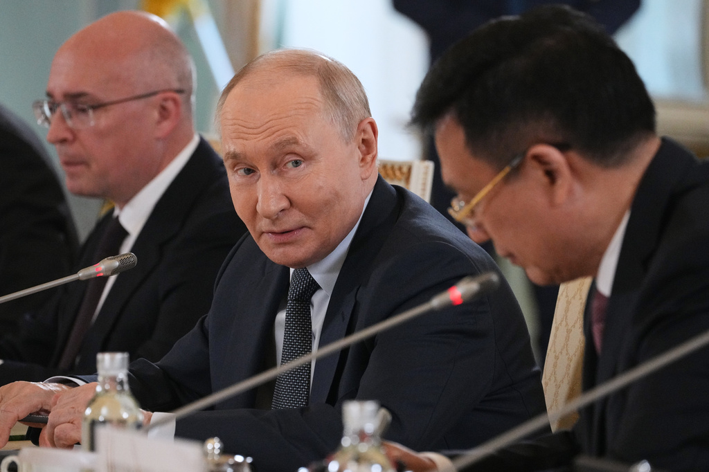 Russian President Vladimir Putin, center, looks at President of Xinhua News Agency Fu Hua, right, while speaking to representatives of international news agencies as General Director of the Russian news agency TASS, Andrey Kondrashov, left, sits near on the sidelines of the St. Petersburg International Economic Forum at the Constantine Palace in St. Petersburg, Russia, on Thursday, June 4, 2026. (AP Photo/Dmitri Lovetsky, Pool)