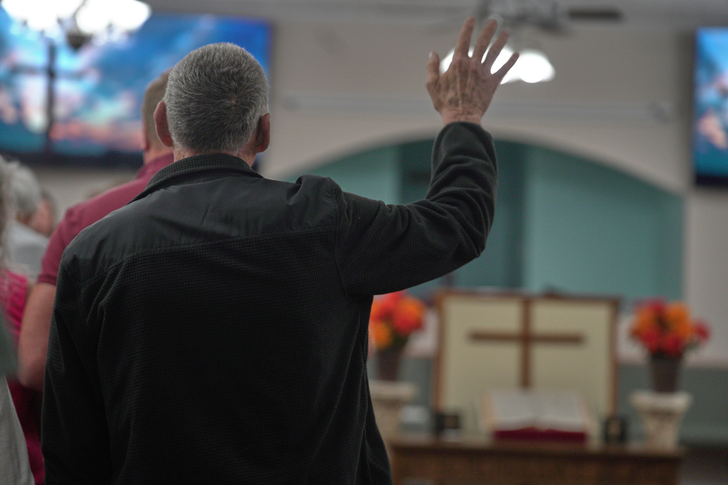 A congregant raises his hand Sunday, Oct. 12, 2025, at Maple Valley Baptist Church in McEwen, Tenn., about 3 miles from Accurate Energetic Systems, an explosives plant where a blast Friday killed 16 people. (AP Photo/Obed Lamy)
