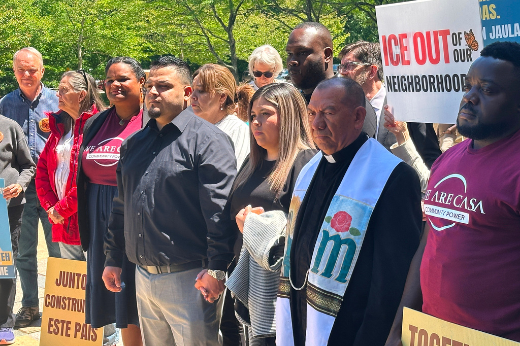 Kilmar Abrego Garcia and his wife, center, hold hands as people rally in support of him at a news conference outside federal court after a hearing in his case on Tuesday, May 12, 2026, in Greenbelt, Md. (AP Photo/Michael Kunzelman)