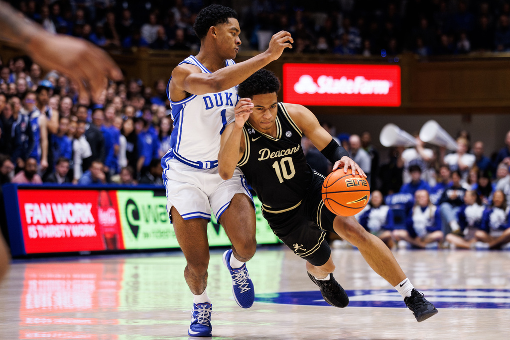 Wake Forest's Sebastian Atkins (10) handles the ball as Duke's Caleb Foster (1) defends during the first half of an NCAA college basketball game in Durham, N.C., Saturday, Jan. 24, 2026. (AP Photo/Ben McKeown)