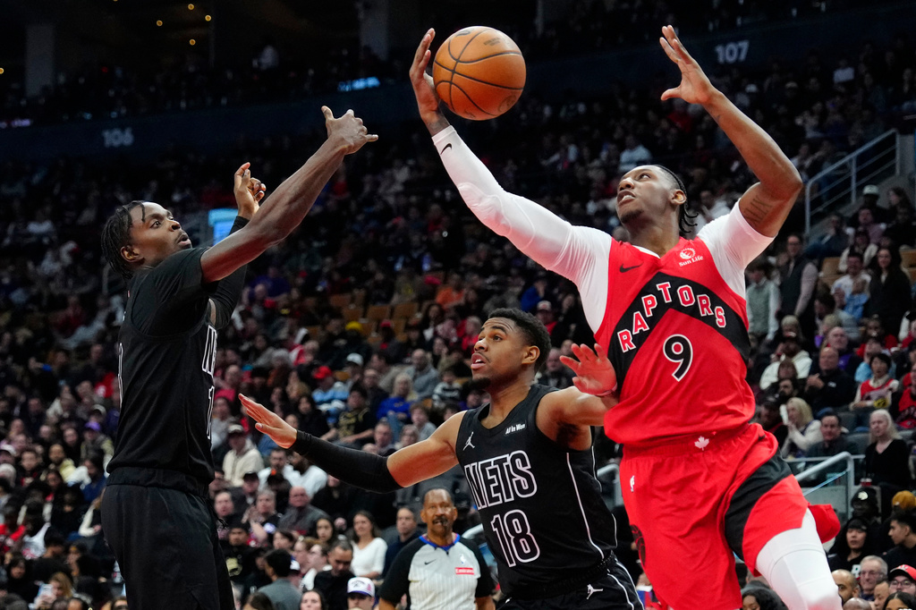 Toronto Raptors forward RJ Barrett (9) scoops the rebound from Brooklyn Nets forward Trevon Scott (13) as teammate Malachi Smith (18) looks on during first half NBA basketball action in Toronto, Sunday, April 12, 2026.(Frank Gunn/The Canadian Press via AP)