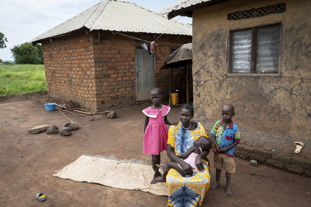 Joy Falatiya, a 35-year-old mother of five children and a client of a specialized mental health clinic led by Amref Health Africa, poses for a photo with her three children in Mundri, South Sudan, June 24, 2025. (AP Photo/Florence Miettaux)