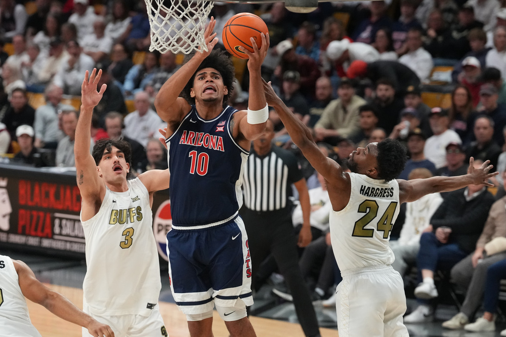 Arizona forward Koa Peat, center, drives to the basket betwen Colorado forward Alon Michaeli, left, and guard Barrington Hargress in the first half of an NCAA college basketball game Saturday, March 7, 2026, in Boulder, Colo. (AP Photo/David Zalubowski)
