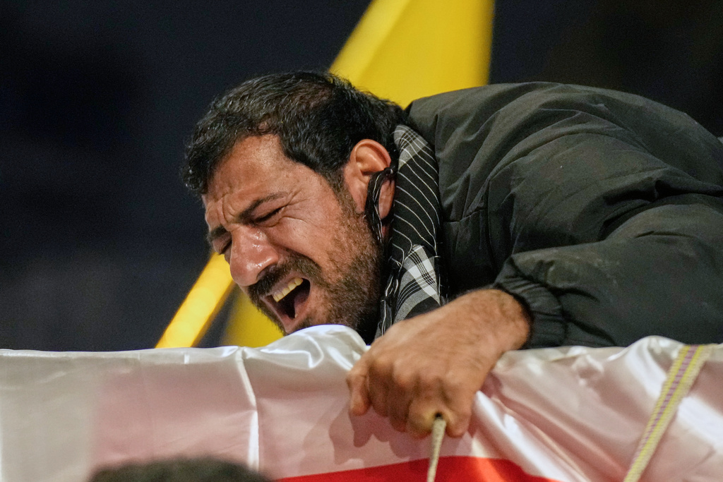 Relatives grieve in Baghdad, Iraq, on Thursday, March 12, 2026, during a funeral for members of the Popular Mobilization Forces who were killed in a U.S. airstrike in Qaim. (AP Photo/Hadi Mizban)