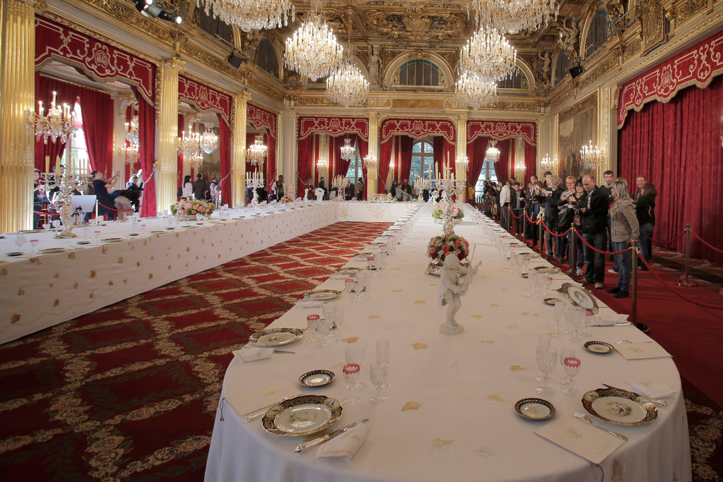 FILE - Visitors view a table dressed with plates and glasses for official dinners at the Elysee Palace in Paris, Saturday, Sept. 15, 2012. France's national buildings and administrations were opened to the public for Heritage Days weekend. (AP Photo/Christophe Ena, File)