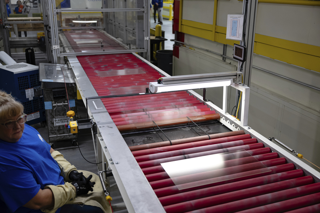 A quality control employee looks on as lengths of glass move down the line during a tour of Corning's iPhone glass manufacturing facility Friday, Sept. 12, 2025, in Harrodsburg, Ky. (AP Photo/Jon Cherry)