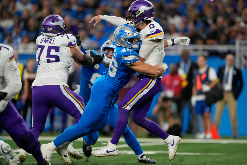 Minnesota Vikings quarterback J.J. McCarthy (9) is hit by Detroit Lions linebacker Jack Campbell (46) during the first half of an NFL football game Sunday, Nov. 2, 2025, in Detroit. Campbell was flagged for roughing passer. (AP Photo/Ryan Sun)