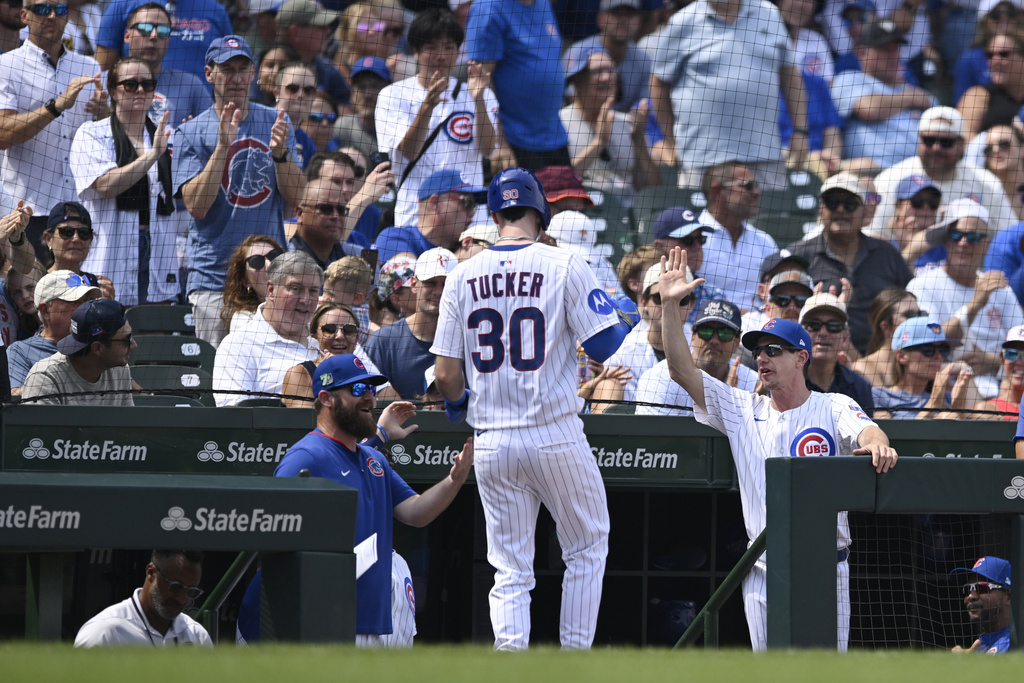 Chicago Cubs' Kyle Tucker (30) celebrates with manager Craig Counsell, right, at the dugout after scoring on a Carson Kelly single during the fourth inning of a baseball game against the Pittsburgh Pirates, Saturday, Aug. 16, 2025, in Chicago. (AP Photo/Paul Beaty)