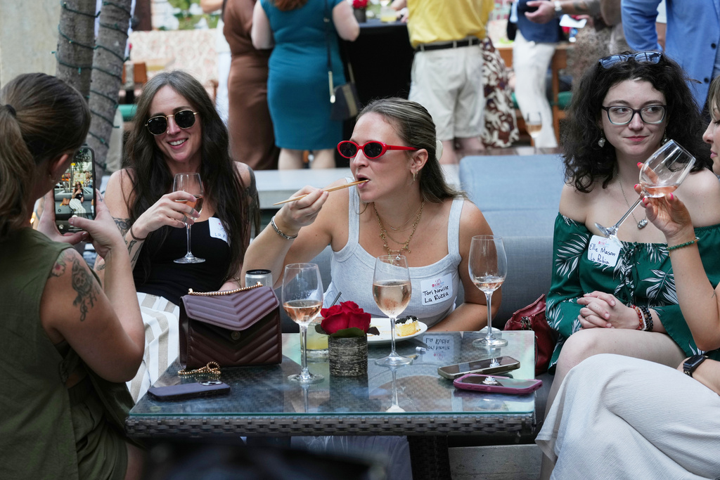 Tori Neville, center, and friends enjoy the food and drinks at the South Beach Wine and Food Festival Friday, Feb. 20, 2026, in Miami Beach, Fla. (AP Photo/Marta Lavandier)
