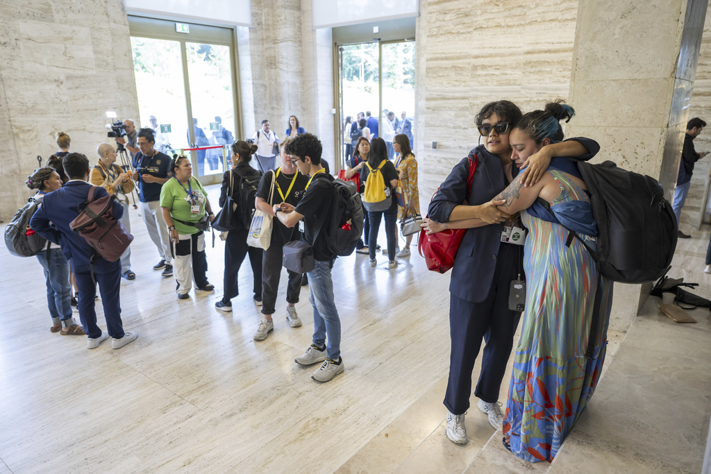 Members of the civil society embrace each other before leaving the second part of the fifth session of the Intergovernmental Negotiating Committee on Plastic Pollution, at the European headquarters of the United Nations in Geneva, Switzerland, Friday, Aug. 15, 2025. (Martial Trezzini/Keystone via AP)