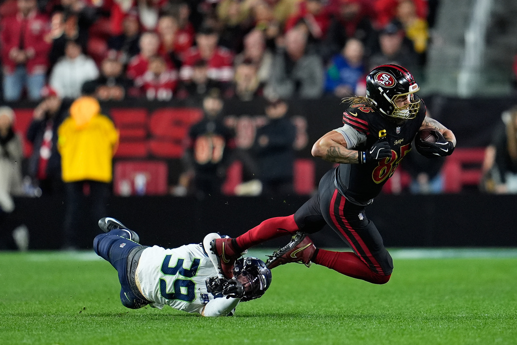 San Francisco 49ers tight end George Kittle, right, is tackled Seattle Seahawks safety Ty Okada (39) during the second half of an NFL football game in Santa Clara, Calif., Saturday, Jan. 3, 2026. (AP Photo/Godofredo A. Vásquez)