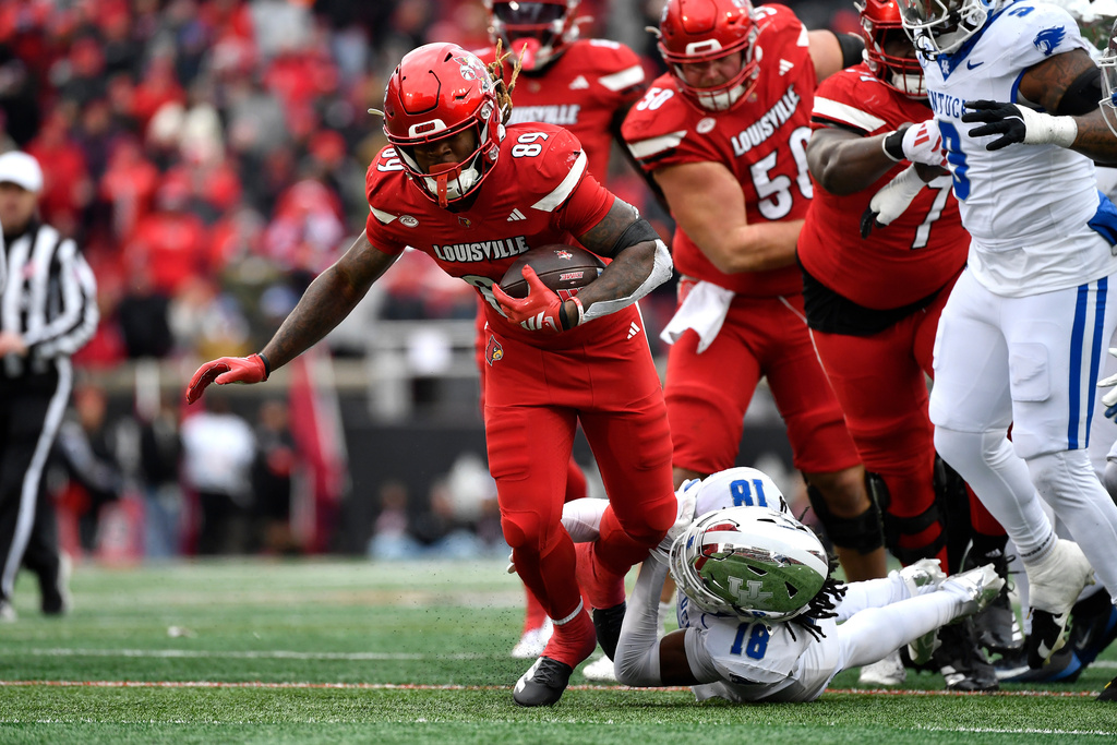 Louisville wide receiver Shaun Boykins Jr. (89) attempts to get away from Kentucky defensive back Cam Dooley (18) during the second half of an NCAA college football game in Louisville, Ky., Saturday, Nov. 29, 2025. (AP Photo/Timothy D. Easley)
