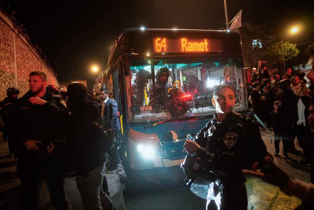 Israeli police inspect a bus following an incident in which it hit ultra-Orthodox Jewish demonstrators blocking a road during a protest against army recruitment in Jerusalem, Tuesday, Jan. 6, 2026. (AP Photo/Ohad Zwigenberg)