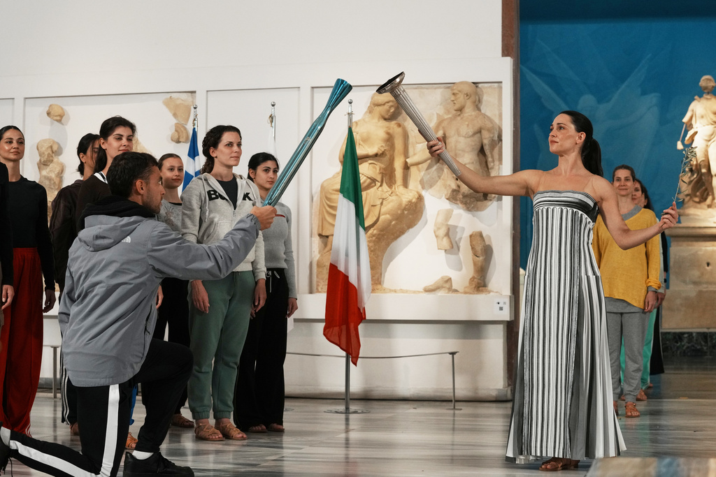 Greek rower and bronze medalist Petros Gaidatzís, left, and actress Mary Mina portraying the High Priestess, perform during the final rehearsal ahead of the flame lighting for the Milan Cortina 2026 Winter Olympics, at the archaeological museum of Olympia, Greece, Tuesday, Nov. 25, 2025. (AP Photo/Thanassis Stavrakis)