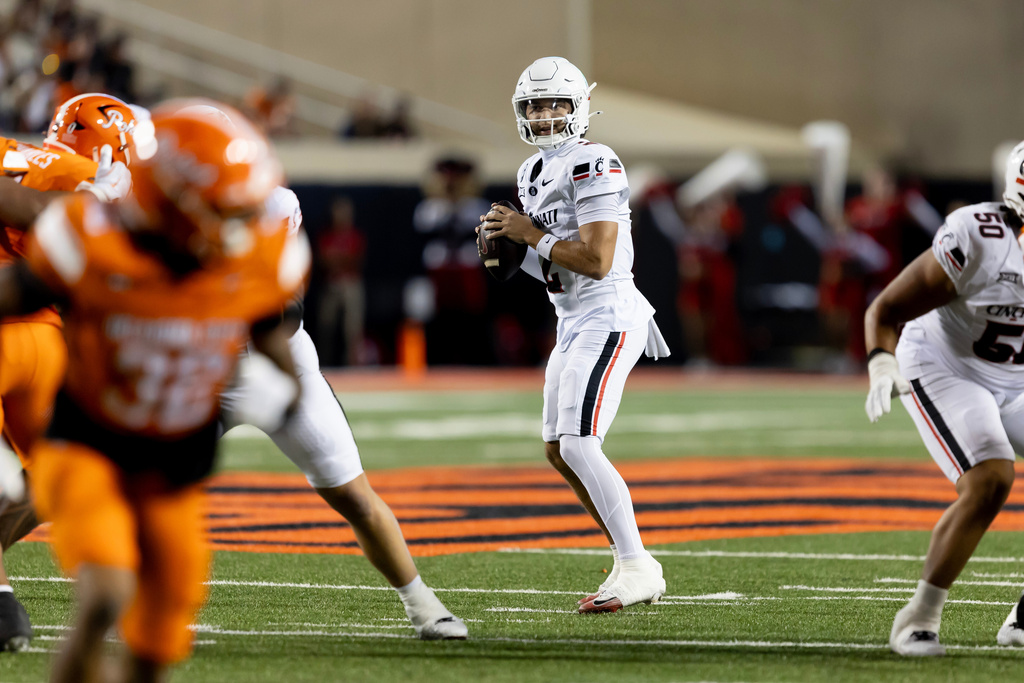 Cincinnati quarterback Brendan Sorsby, center, drops back to throw a touchdown pass in the first half of an NCAA college football game against Oklahoma State, Saturday, Oct. 18, 2025, in Stillwater, Okla. (AP Photo/Mitch Alcala)