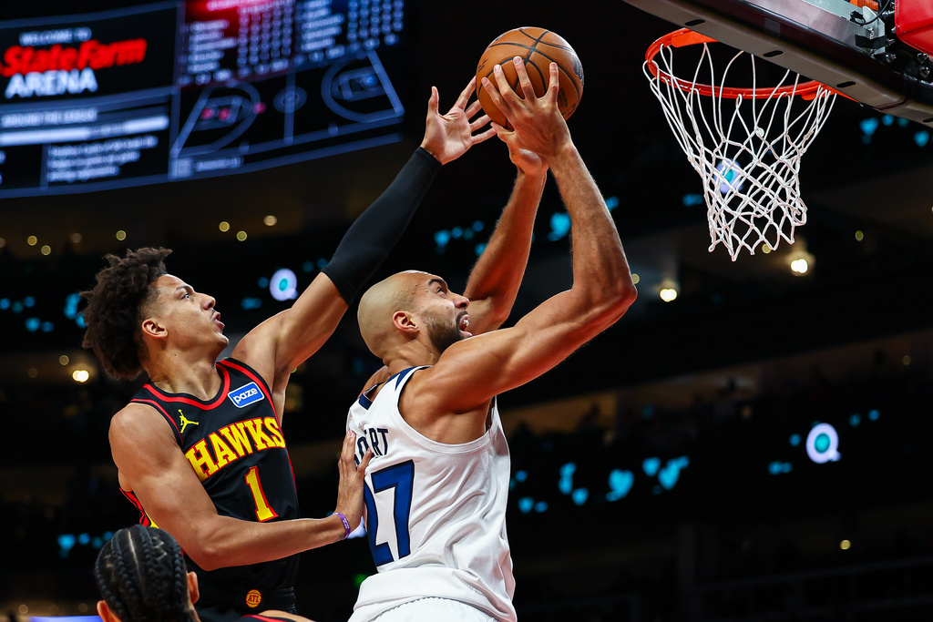 Atlanta Hawks forward Jalen Johnson (1) defends a shot by Minnesota Timberwolves center Rudy Gobertm during the first half of an NBA basketball game, Wednesday, Dec. 31, 2025, in Atlanta. (AP Photo/Colin Hubbard)