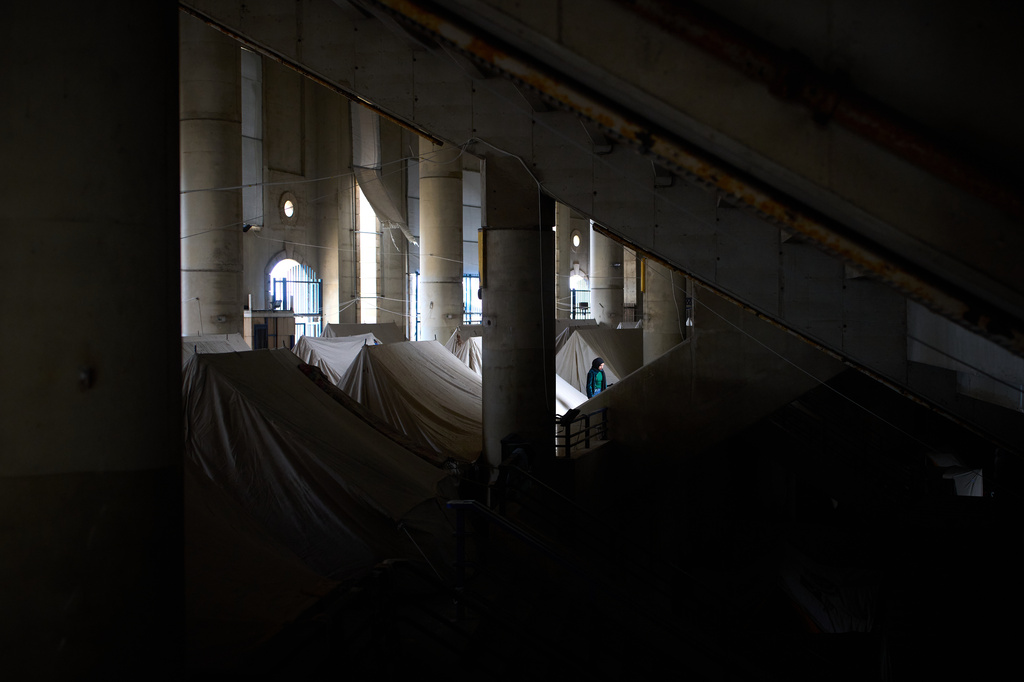 A displaced woman walks next to tents set up inside the Camille Chamoun Sports City Stadium, which has been turned into a shelter for people displaced by Israeli airstrikes in southern Lebanon, in Beirut, Lebanon, Monday, March 30, 2026. (AP Photo/Emilio Morenatti)