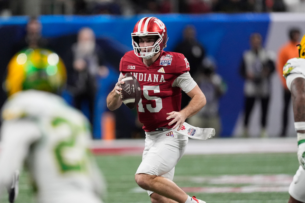 Indiana quarterback Fernando Mendoza (15) carries against Oregon during the first half of the Peach Bowl NCAA college football playoff semifinal, Friday, Jan. 9, 2026, in Atlanta. (AP Photo/Mike Stewart)