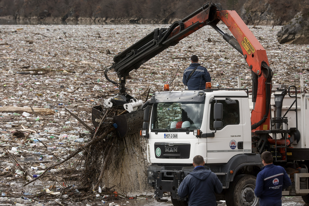 Workers use a crane to remove waste clogging the Drina river in Visegrad, Bosnia, Thursday, Feb. 5, 2026. (AP Photo/Armin Durgut)