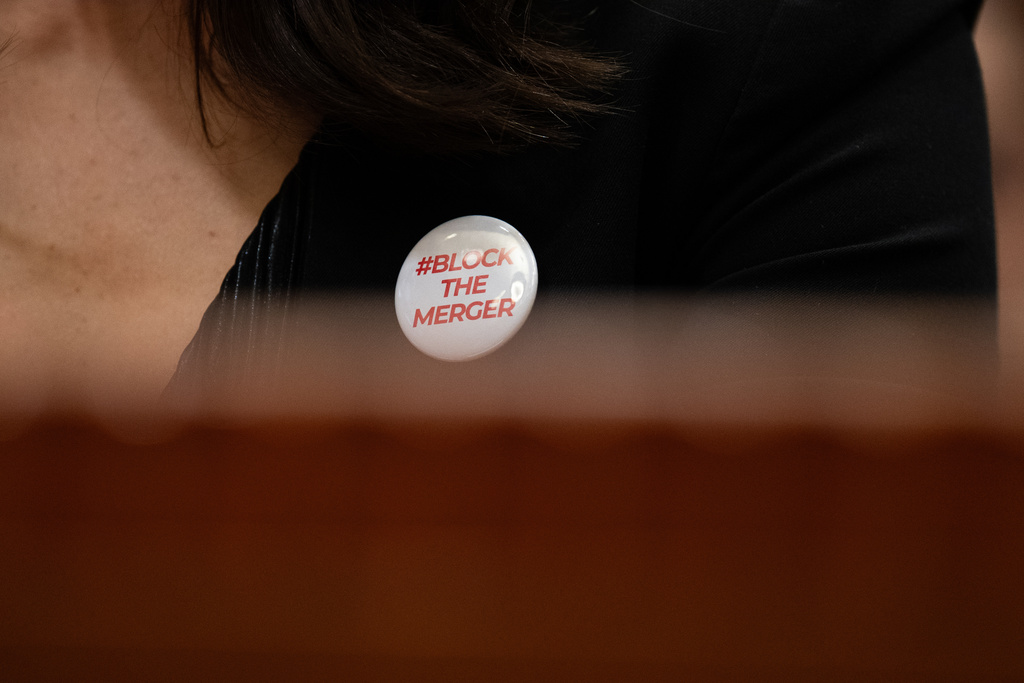 Jax Deluca wears a button calling to block media mergers during a hearing on the challenges facing the film industry in Burbank, Calif., Friday, March 20, 2026. (AP Photo/Jae C. Hong)