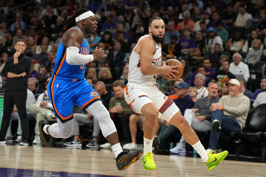 Phoenix Suns forward Dillon Brooks drives past Oklahoma City Thunder guard Luguentz Dort (5) during the second half of an NBA basketball game, Wednesday, Feb. 11, 2026, in Phoenix. (AP Photo/Rick Scuteri)