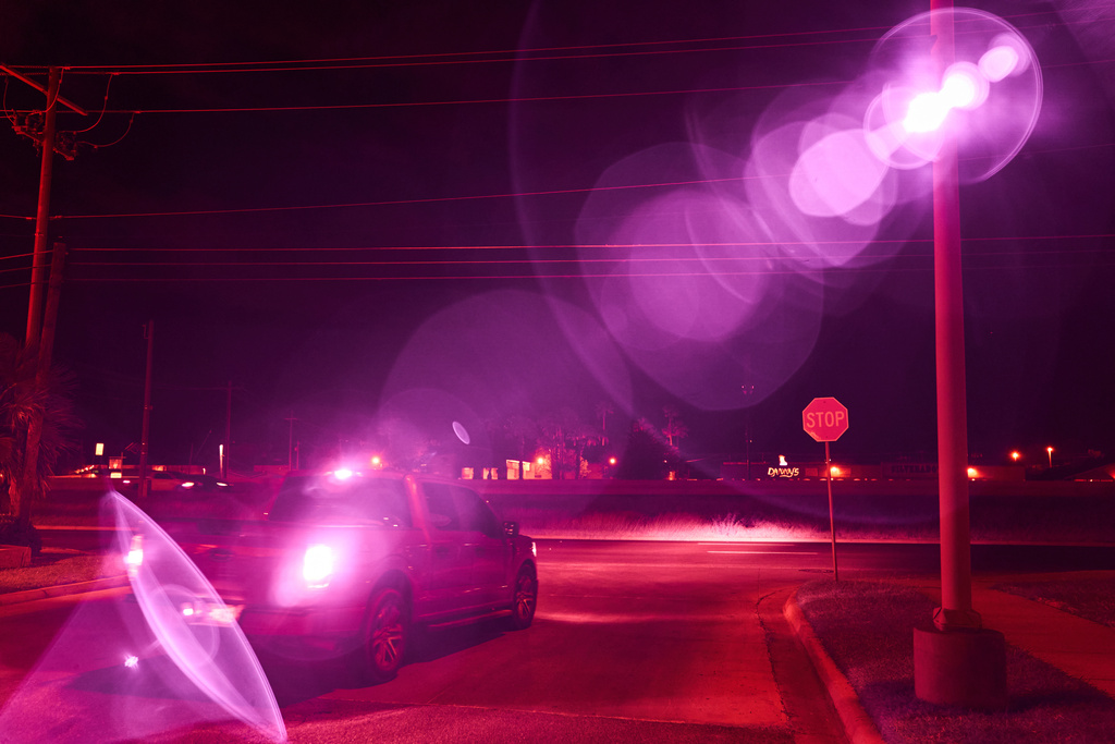 An infrared beam of light shines out of an automatic license plate reader as it records vehicles driving by, Oct. 13, 2025, in Laredo, Texas. (AP Photo/David Goldman)