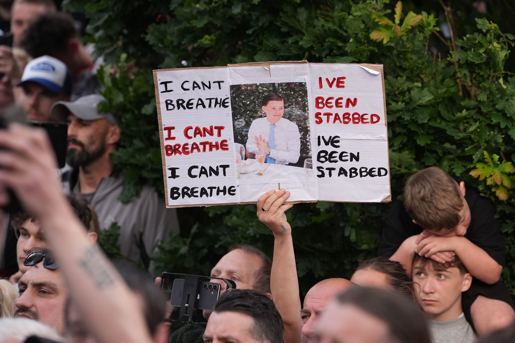 People protest outside the police station in Southampton, England, on Tuesday, June 2, 2026, one holding a photo of December 2025 stabbing victim Henry Nowak, 18. (Gareth Fuller/PA via AP)