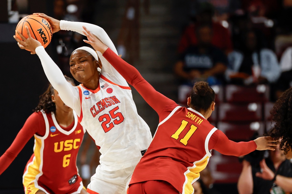 Clemson forward Demeara Hinds (25) protects the ball from Southern California guard Kennedy Smith during the first half of the first round of the NCAA college basketball tournament, Saturday, March 21, 2026, in Columbia, S.C. (AP Photo/Nell Redmond)