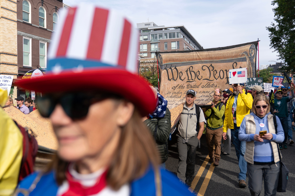 FILE - Demonstrators carry a signed banner representing the U.S. Constitution as they march to the national Mall during a No Kings protest in Washington, Oct. 18, 2025. (AP Photo/Jose Luis Magana, File)